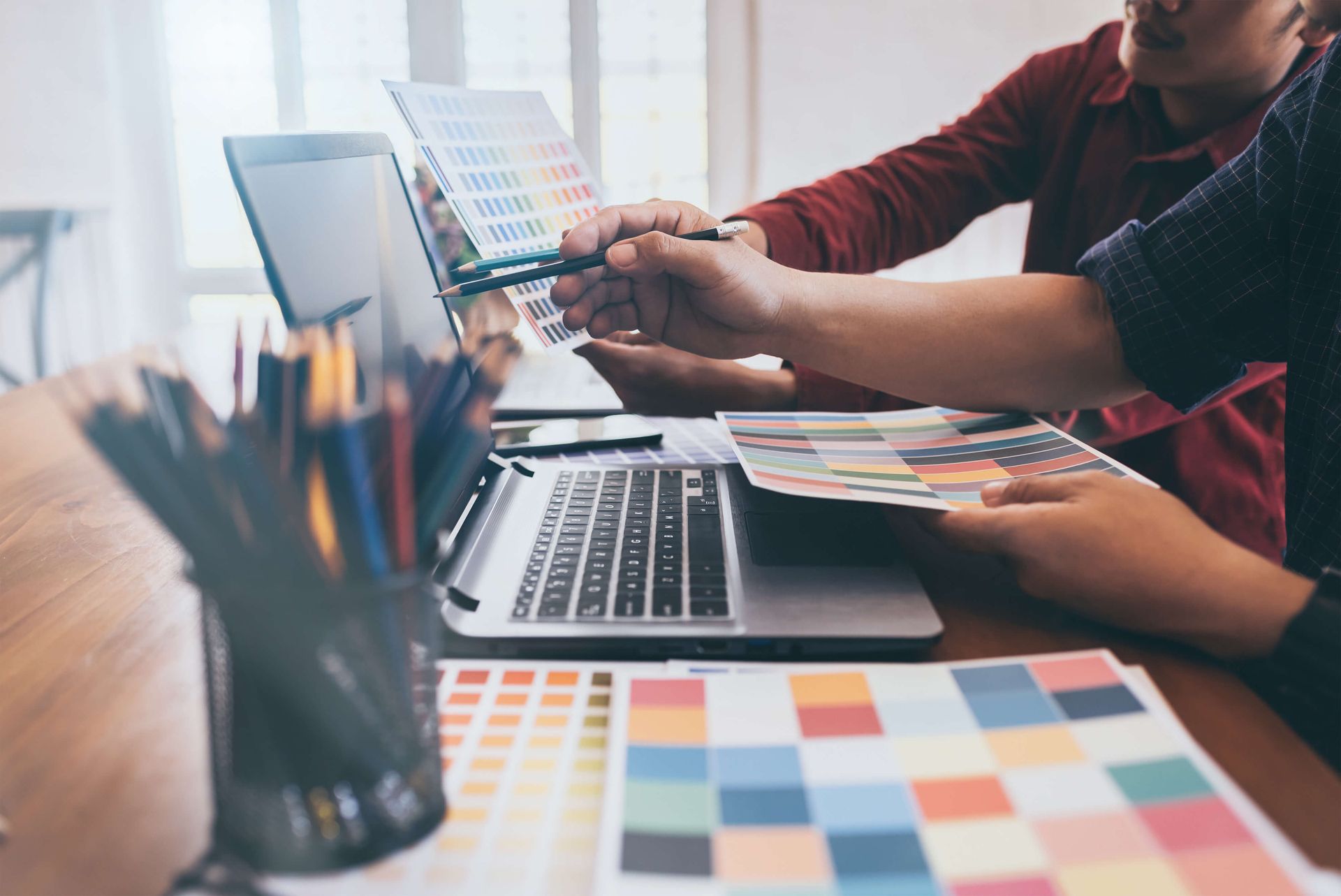 Grafikdesigner mit Farbtabellen und Laptop